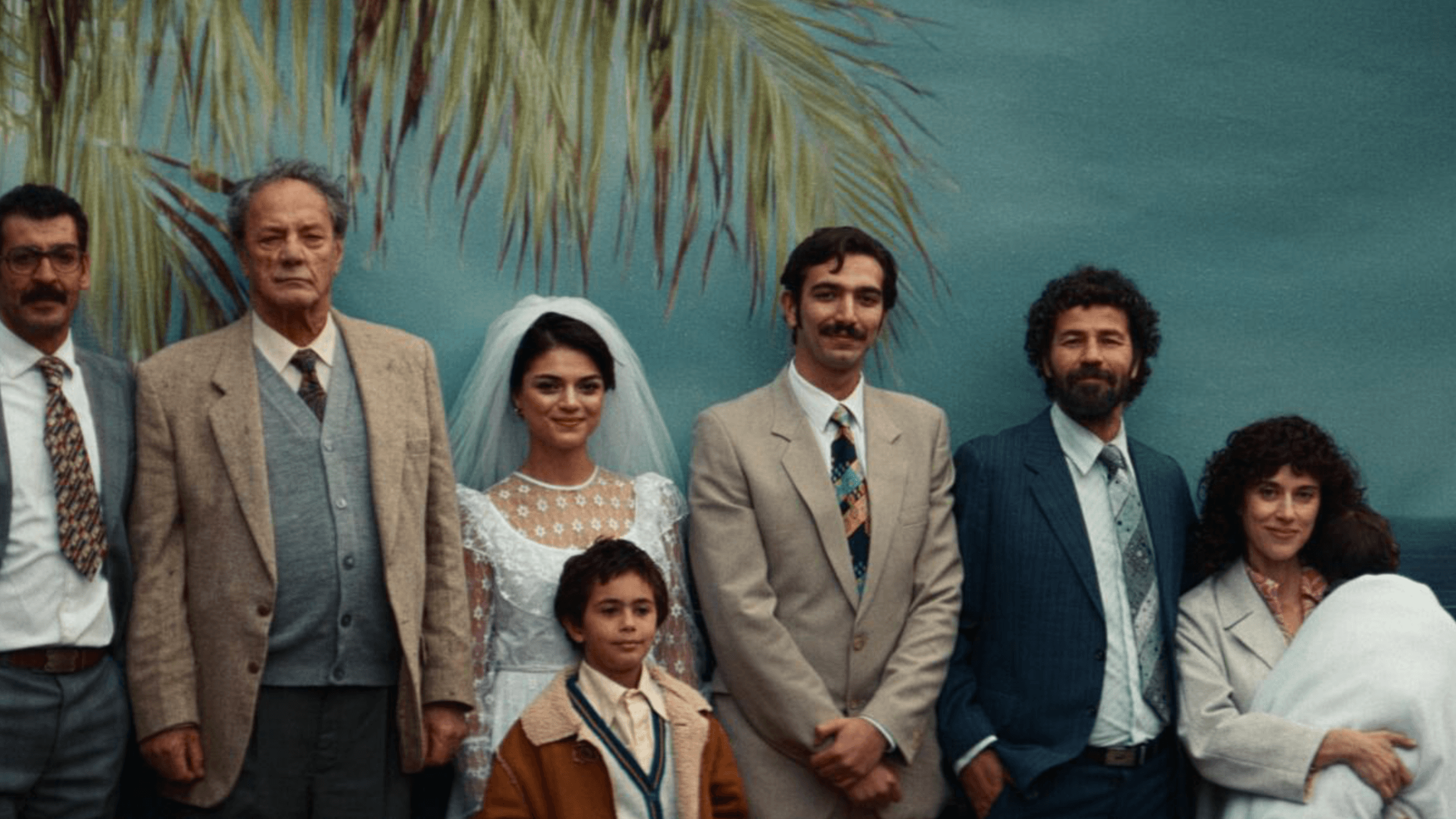 A Palestinian family poses for a formal group portrait in front of a palm-print backdrop in 'All That's Left of You'.